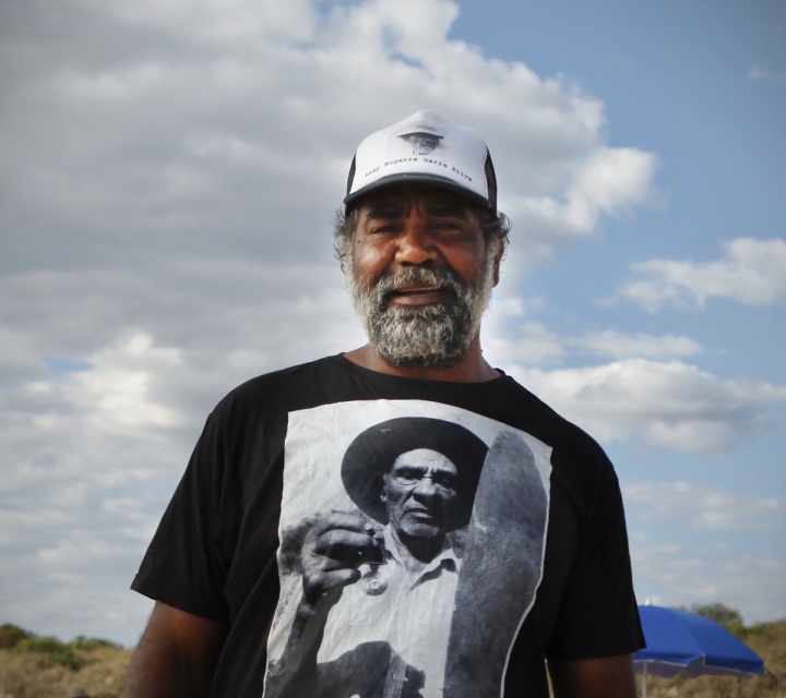 Figure 2: Joe Roe wearing a T-shirt commemorating his grandfather Paddy Roe, carrying both his traditional shield and his Order of Australia. Photo Talhy Stotzer.
